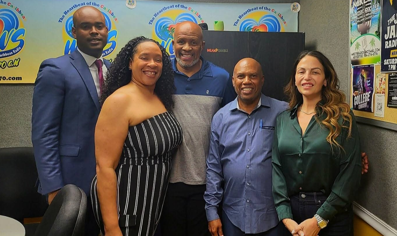 Niccole Pazos, at right in green, with a group inside the WAVS 1170 AM studio